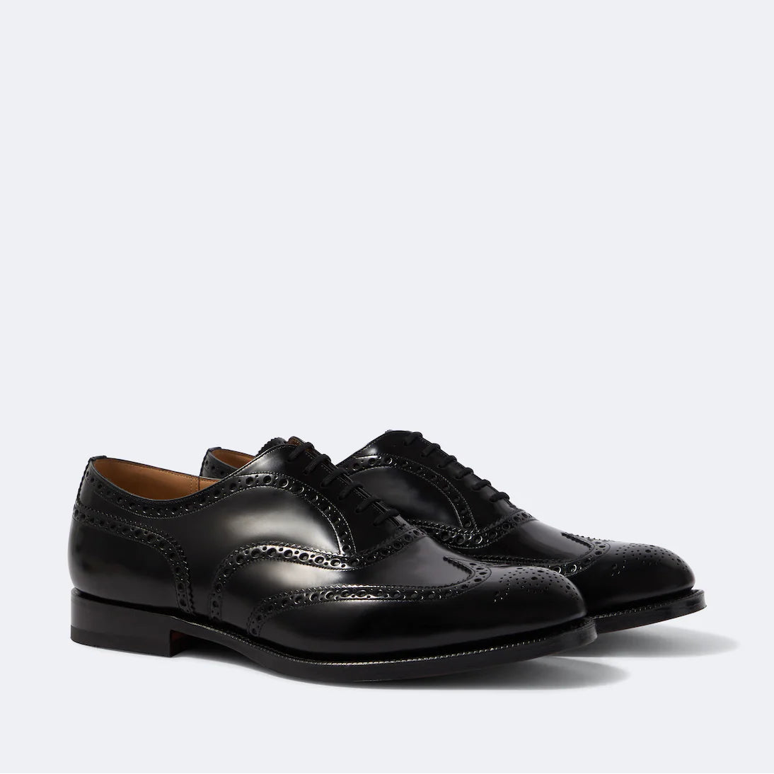 Pair of black leather dress shoes on a light gray background